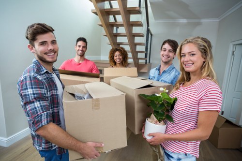 Movers working together safely with packed items and trolleys